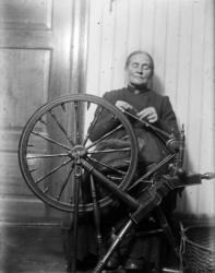 Eldre kvinne spinner garn med rokk, spinnerokk.