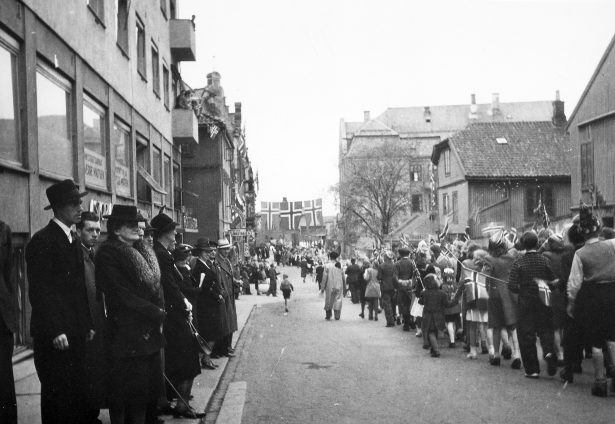 Skoletoget 17. mai 1945 passerer gjennom Torggata utenfor Astoria hotell. 
Fredsdagene etter 2. verdenskrig. 