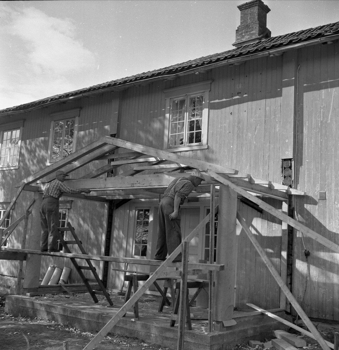 SKØYEN GÅRD, LØTEN. PÅBYGG AV VINDFANG, SNEKKERE I ARBEID. 