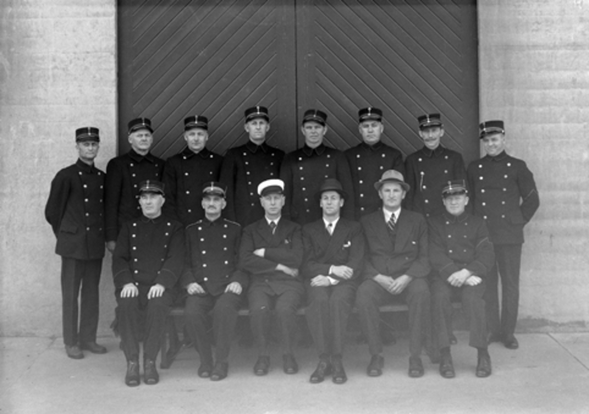 HAMAR BRANDKORPS, HAMAR BRANNVESEN, GRUPPE BRANNMENN I UNIFORM, 30-6-1939. 
1. rekke fv: Karl Alfstad, O. T. Harildstad, Gunleik Rasch-Halvorsen, Nils Nyquist, Aldor M. Vennestrøm og Harald Kristiansen. 2. rekke fv: Ingvart Rørbakk, Mikkel Marthinsen, Emil Evensen (senere Eifring), Sigvart Aasen, Anton Martinsen, Thorvald Tollefsen, Einar Løvhaug og Ivar Nybakken. 