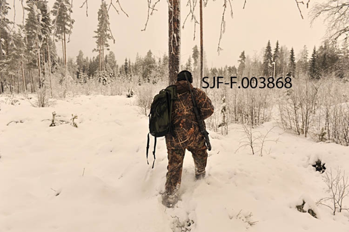 Fra bygginga av Geithus Bruk på Modum i Buskerud.  Bildet, som er sammensatt av to opptak, er tatt fra den søndre enden av det som skulle bli fabrikkområde.  Fotografiet viser hvordan man på dette tidspunktet, 24. mai 1965, hadde forskalet og støpt fundamenter for en del søyler langs den ene langveggen.  Ved den motsatte langveggen og gavlveggen ser vi at det er forskalet for veggmurer.  Bakenfor byggeplassen ses et bolighus samt en del furuskog.  Geithus Bruk var en virksomhet som kjøpte tømmer for barking og flishogging.  Flisa ble levert til Skotselv Cellulosefabrikk i Øvre Eiker. 