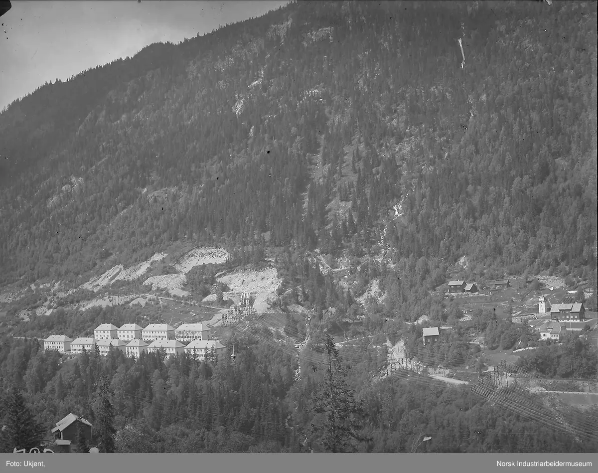 Bebyggelse på Krosso med 10 murhus og noe bebyggelse i Fjellveien og Villaveien sett fra Vemorksporet. Trafostasjon i Villaveien. Masseuttak i fjellsiden. Bolighus på sørsiden av juvet ved Vemorksporet.