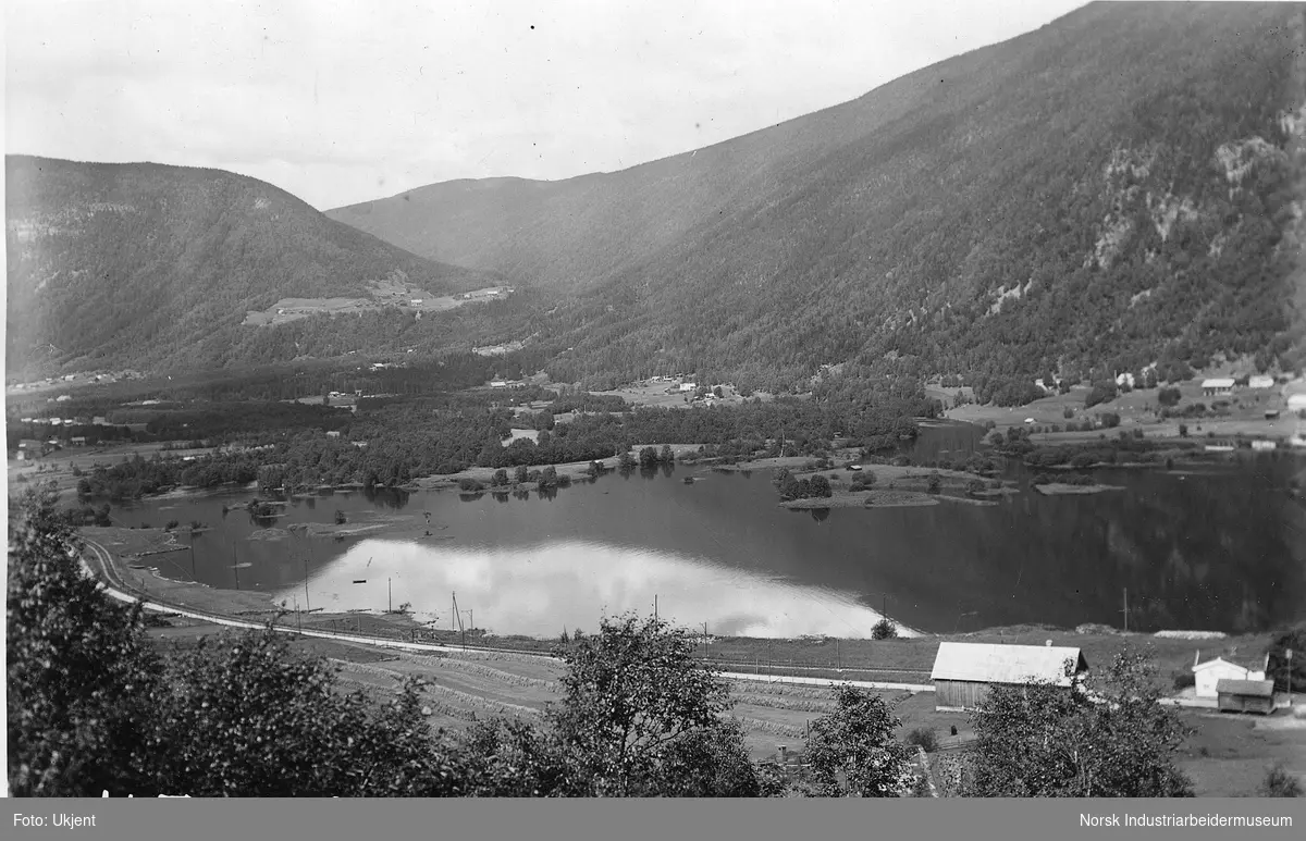 Månaelvens utløp i Tinnsjøen. Tatt fra Mælsiden. Vannstand i Tinnsjøen 191.03. Gårdsbebyggelse på Miland og Bergshaugen.