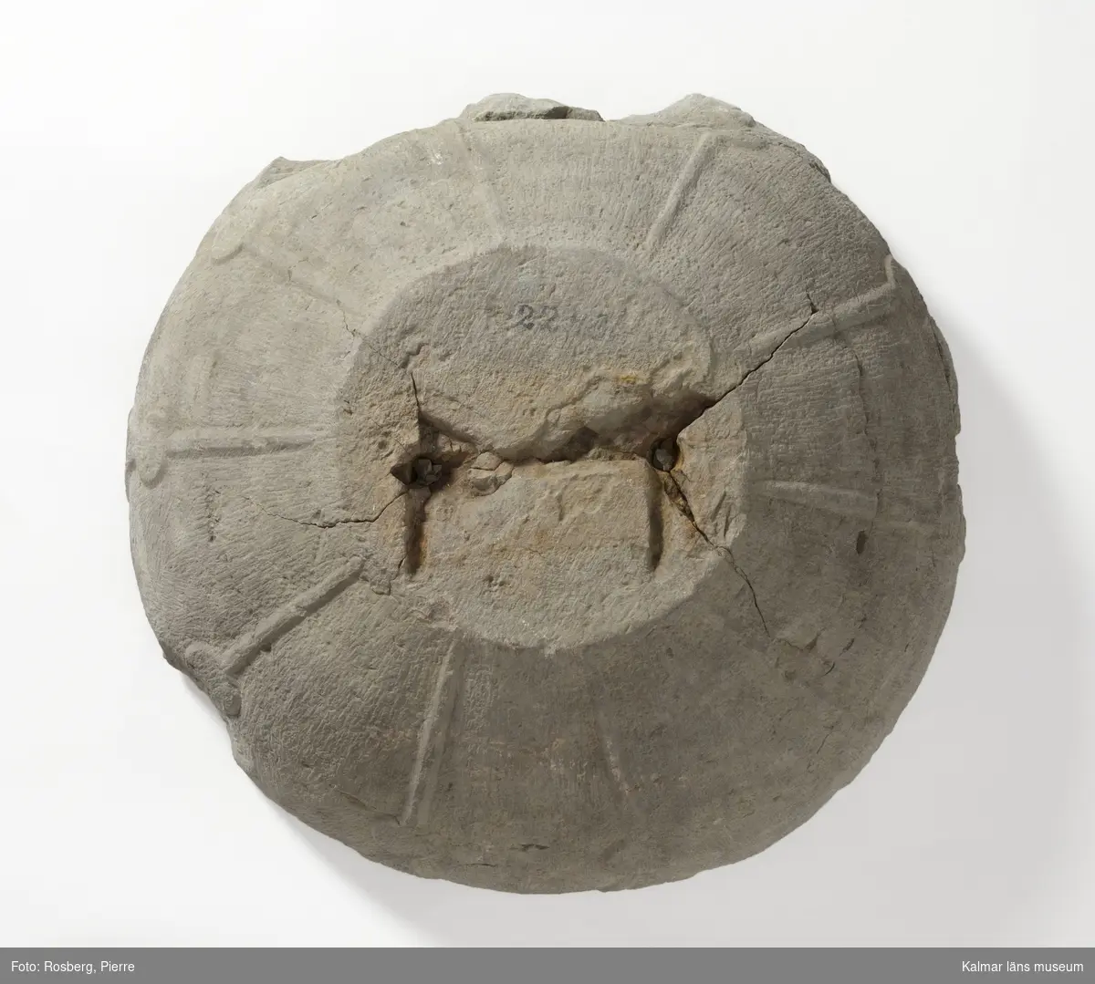 KLM 22431. Dopfunt, del av. Av kalksten, huggen. Botten av cuppan till godronnerad funt. Daterad till 1200-tal. Jfr. KLM 22766. Det finns vissa likheter.