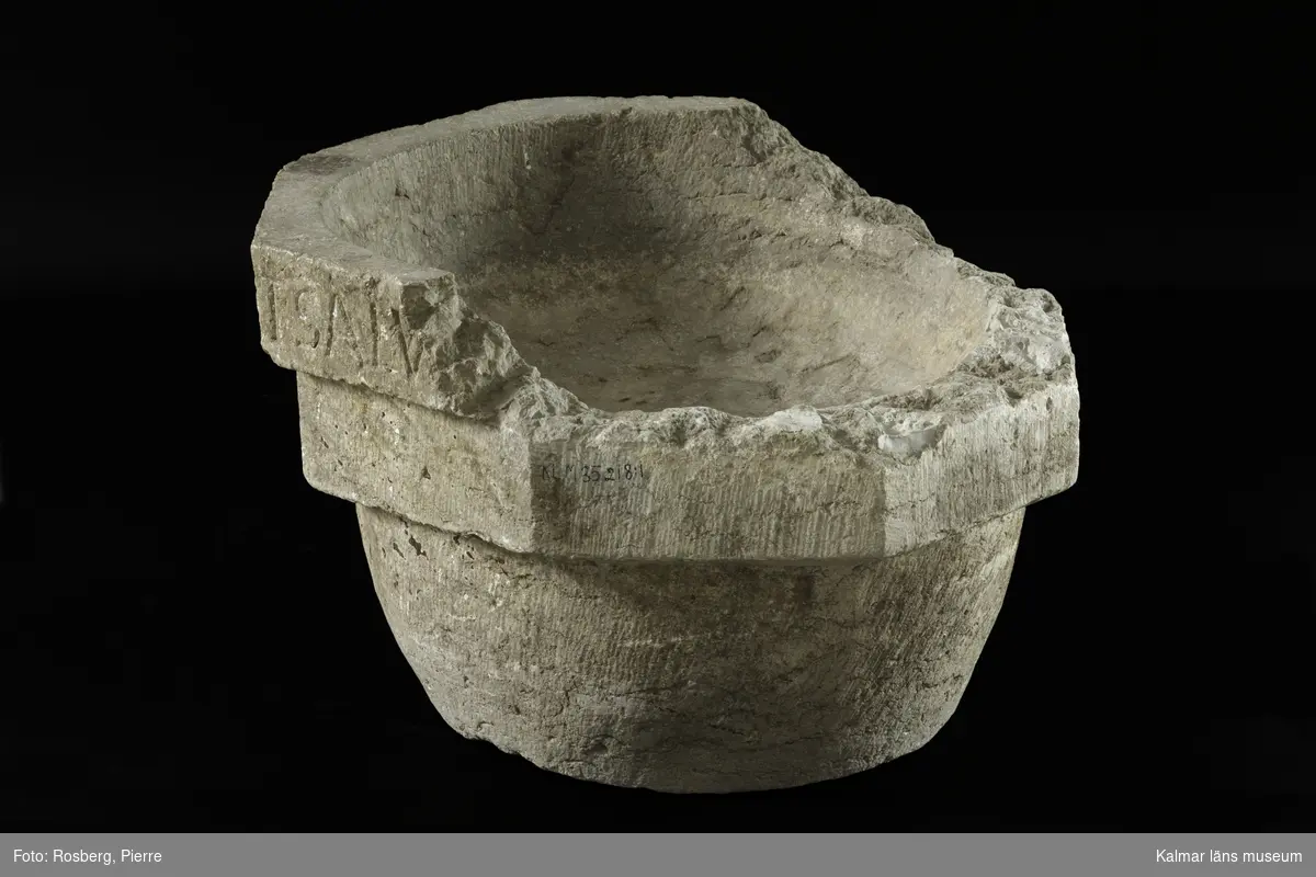 KLM 35218:1:1-4. Dopfunt, av kalksten, består av 4 delar. :1:1. Dopfuntscuppa, mått: mynning yttre diameter 65 cm, inner diameter 50 cm, skåldjup 18 cm, botten diameter 40 cm. Cuppan utförd i tre nivåer, de två övre delarna är åttakantiga och underdelen cylindrisk med svag konisk-konvex profil. Den övre åttakantiga nivån med latinsk inskription, text med versaler, inskrift: ...ERIT ET BABTATUS FUERIT SALV... Den undre åttakantiga nivån har texten ...RIT CONDEMNABITUR. (Inskriften är ej helt komplett, del av citat från, Marcus 16:16. Hela citatets översättning, Bibeln 2000: Den som tror och blir döpt skall räddas, men den som inte tror skall bli dömd.)  Den undre nivån har kryssristad dekor. Underdelen är odekorerad. Grund skål. Cuppans överkant, är till hälften bortslagen, tre av bitarna finns kvar. Utan uttömningshål. :1:2-4 tre lösa delar tillhörande övre kanten av cuppan. Alla tre delar har otydlig latinsk inskription, text med versaler och tecken.