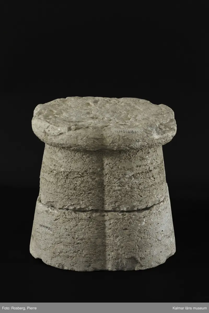 KLM 35218:2:1-2. Dopfuntsfot, av kalksten, 2 delar. Mått, hela foten: höjd 40 cm, största bredd 43 cm. Foten sammansatt av fyra halvkolonner, konade med fyrklöverformad vulst upptill. Saknar fotplatta. Foten som är det enda som återstår av funten är eroderad efter lång tid utomhus. Den har en liten skada vid skarven och en horisontell spricka.