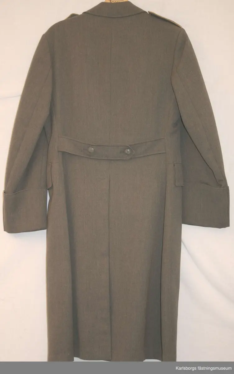 Kappan är dubbelknäppt och knäppes framtill med 5 st stora knappar m/1939. Kappan har axelklaffar, sidfickor och ryggsleif med två knappar. Slits i ryggen. En knapp saknas fram. Gradbeteckning och kompanisiffra 2 på axelklaffarna.