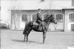 Livhusar i uniform m/1895 med tilldelad stamhäst utanför ridhuset.