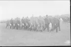 Deltagarna i kamratdagen 7 juni 1937 marscherar ut till uppställningsplatsen på fältet söder om kasern för att lämna av till sekundchefen. I bakgrunden den beridna musikkåren med vit pukhäst.