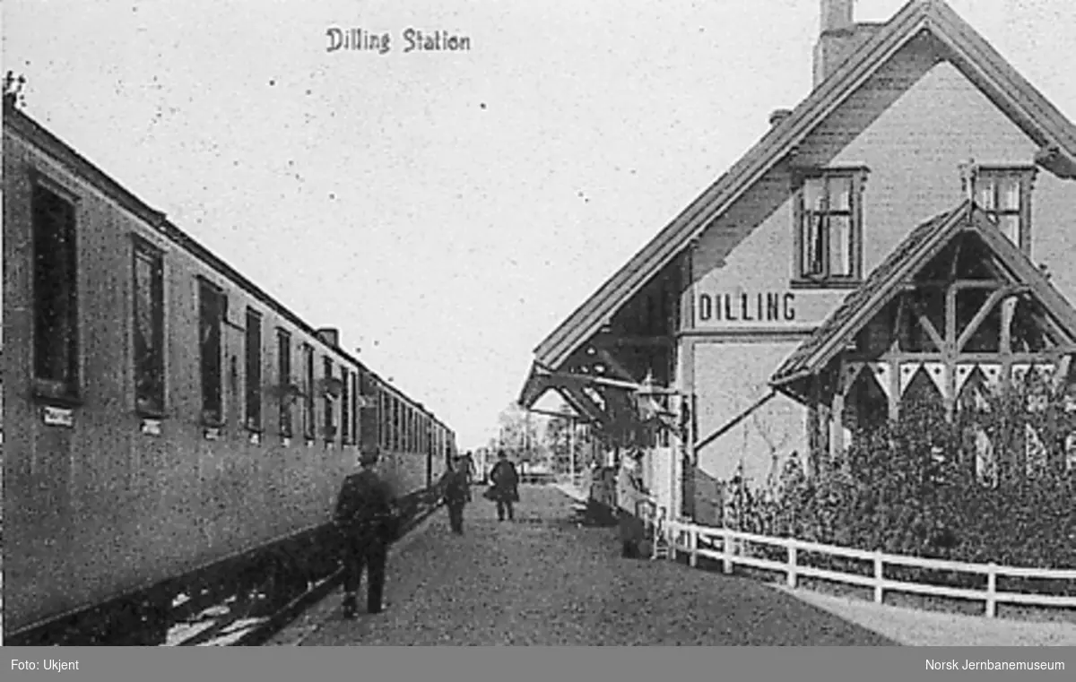Dilling stasjonsbygning med persontog ved plattformen
