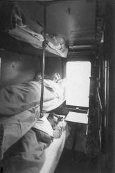 Interiørbilde fra 3. klasse sovevogn med tre reisende