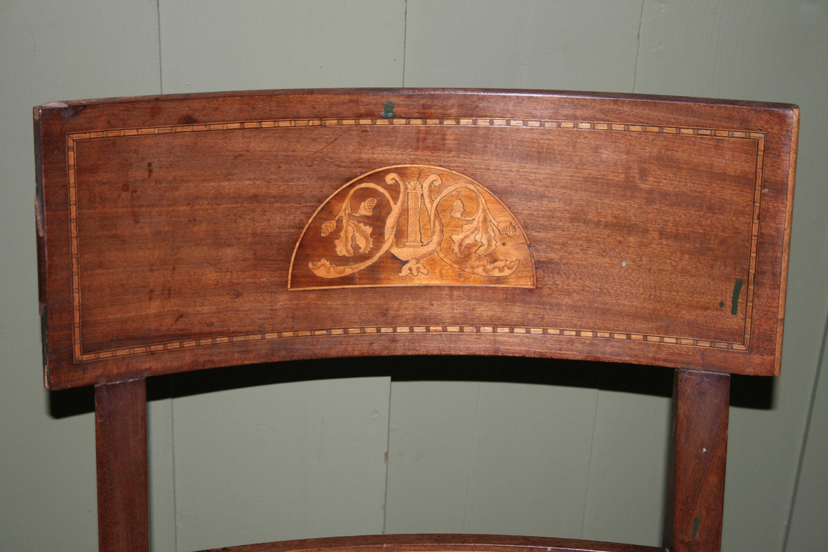 Intarsia på ryggbrett, lyre og eikeløv.