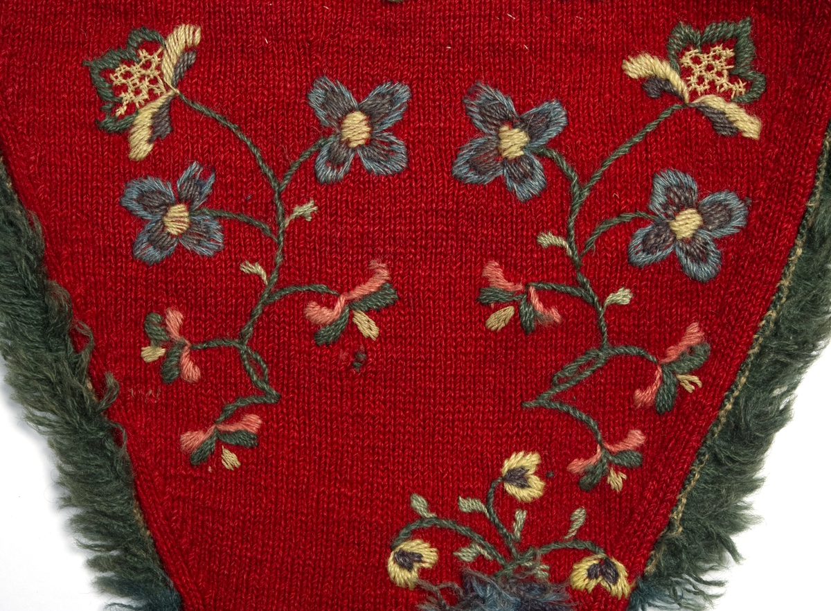 Rød stikket fingervante av ull, dekor av broderi og fryns.