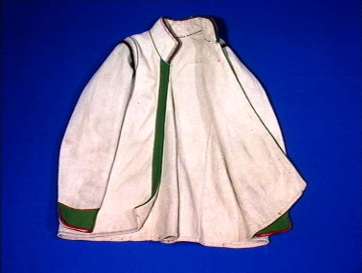 Hvit mannskofte av vadmal med gønne kanter av klede (oppslag).
Nedrekanter, ermebryninger og halskrage har dekor av rød korstign avgrenset av blått konturstign (ullgarn).
Halskrage ha kanting av svartklede med tittkant av rødt klede.
Ermer har et ca. 6,5 cm bredt belegg av grønn klede kantet med rødt klede.