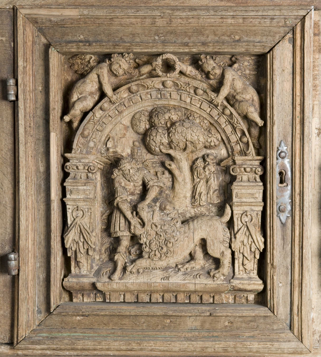 Rektangulært skap med skåret ornamentikk i flere deler. Øvre skap med to dører og gesims. Nedre skap med en klaff fremstilt som to dører. Skapdelene står på en sokkel med fire ben. Tympanon på øvre skap. Skapet ble opprinnelig brukt som skjenk med åpen klaff for å servere drikkevarer til gjester.
På overskapet i dørfyllinger er utskåret motiv fra gamle testament: "Samsons kamp med løven" og "Samson bærer bort Gazas byport". På underskap i fyllinger: "Samson slår filisterne med asenkjeven" og "Samson og Dalila". Dørene blir flankert av hermenpilaster. Mellom fyllinger på overskap aedikula med dyden "kjærlighet".  Som karyatide og atlant to utskårete figuerer "Adam og Eva" ved overskap. 
Klassiske profiler med eggstav, perlestav og tannsnitt. Beslagverkornament på skapsidene, gesimsens underside og profil på underskap. 
Utskårete hoder av løver, engler, kvinner, masker på gesimsens underside og profil på underskap. Sidebrett med hermer, portretter i medaljonger og beslagverk. Sokkelen består av dreide og utskårete ben, holdt av en ramme, Forsidens blending er dekorert med utskårete figurer og ornamenter i ørebruskstil.
Flere deler er sekundære.