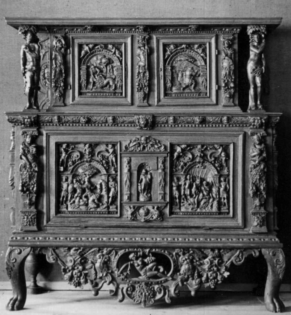 Rektangulært skap med skåret ornamentikk i flere deler. Øvre skap med to dører og gesims. Nedre skap med en klaff fremstilt som to dører. Skapdelene står på en sokkel med fire ben. Tympanon på øvre skap. Skapet ble opprinnelig brukt som skjenk med åpen klaff for å servere drikkevarer til gjester.
På overskapet i dørfyllinger er utskåret motiv fra gamle testament: "Samsons kamp med løven" og "Samson bærer bort Gazas byport". På underskap i fyllinger: "Samson slår filisterne med asenkjeven" og "Samson og Dalila". Dørene blir flankert av hermenpilaster. Mellom fyllinger på overskap aedikula med dyden "kjærlighet".  Som karyatide og atlant to utskårete figuerer "Adam og Eva" ved overskap. 
Klassiske profiler med eggstav, perlestav og tannsnitt. Beslagverkornament på skapsidene, gesimsens underside og profil på underskap. 
Utskårete hoder av løver, engler, kvinner, masker på gesimsens underside og profil på underskap. Sidebrett med hermer, portretter i medaljonger og beslagverk. Sokkelen består av dreide og utskårete ben, holdt av en ramme, Forsidens blending er dekorert med utskårete figurer og ornamenter i ørebruskstil.
Flere deler er sekundære.