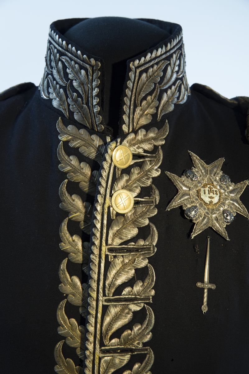 Mørkblå frakk med dekor av metallbroderi.