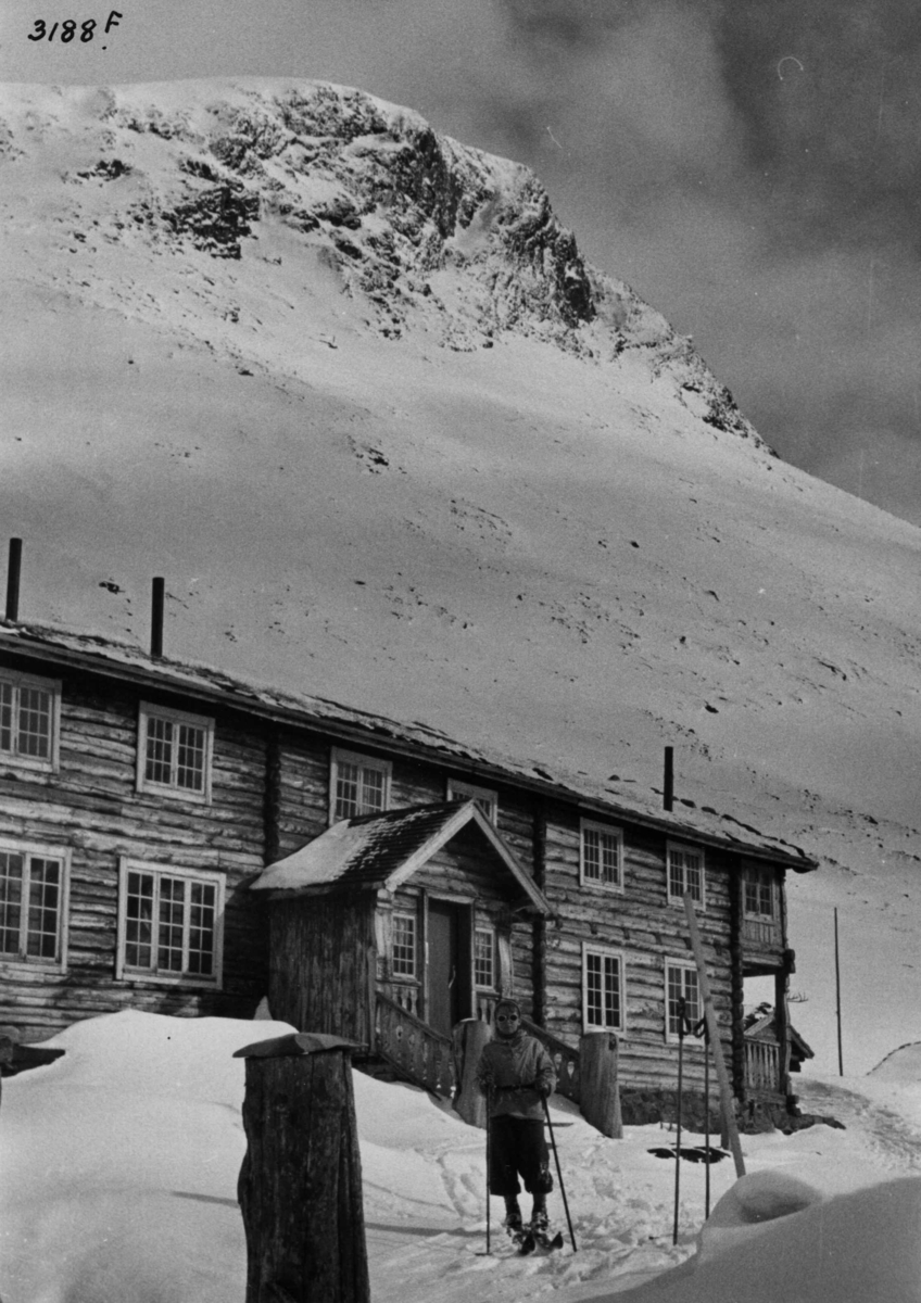 Skiløper ved Spiterstulen i Visdalen i Jotunheimen med snødekte fjell.