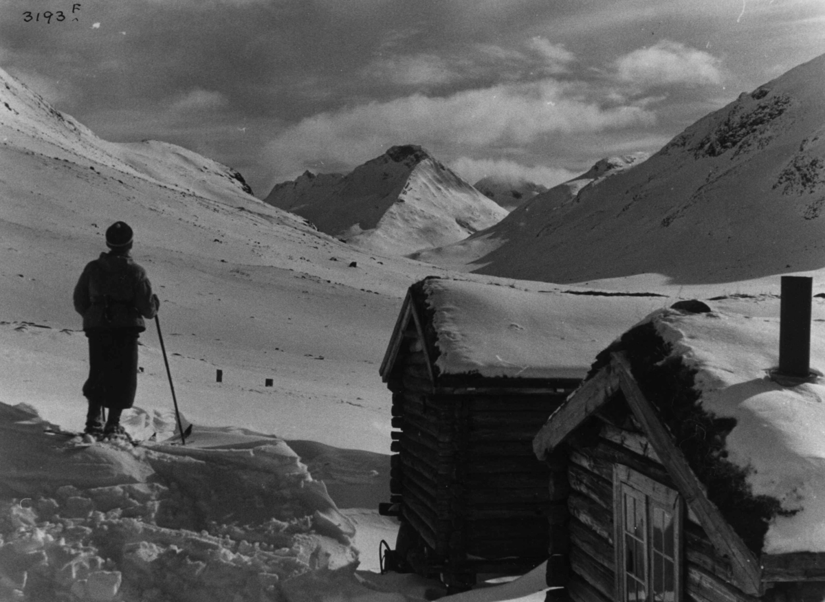 Skiløper ved Spiterstulen i Visdalen i Jotunheimen med snødekte fjell.