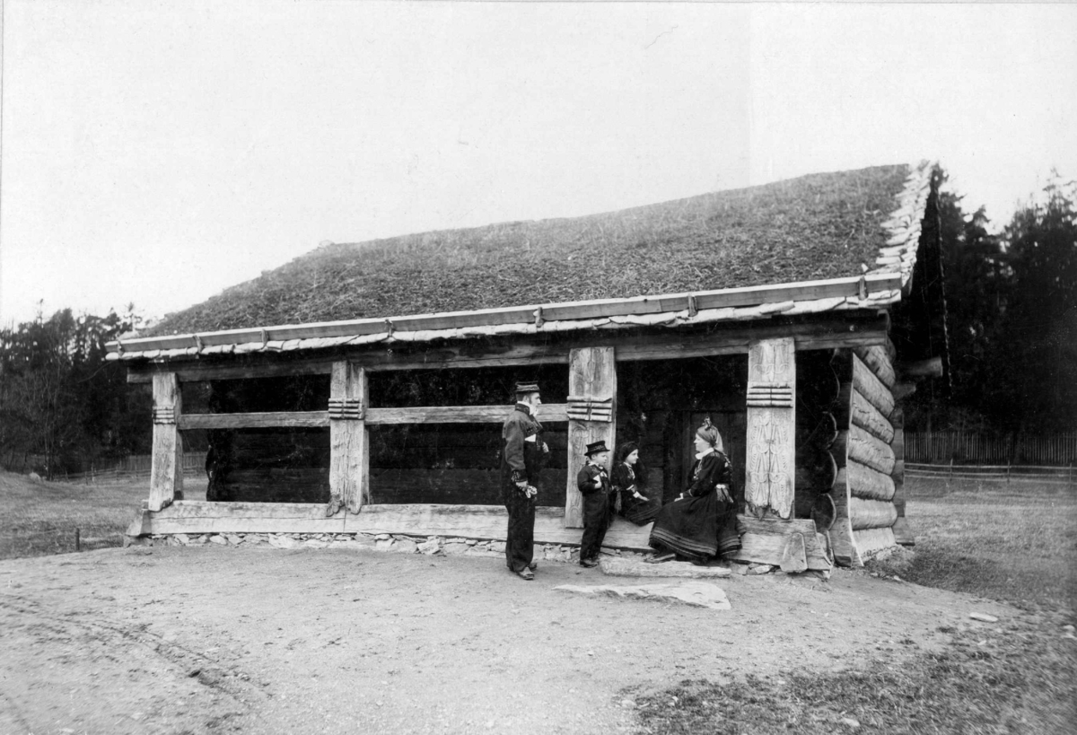 Åmlidstua fra Setesdal. Fotografert på Norsk folkemuseum, 1902.
Sittende: Tone Uppstad.