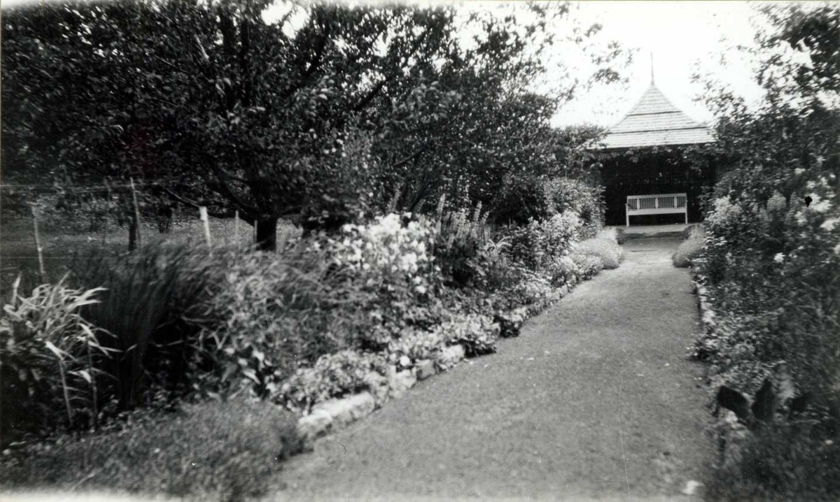 Lagåsen, Bærum, Akershus. Hage med gangsti mellom blomsterbedd. Krakk i lysthus.