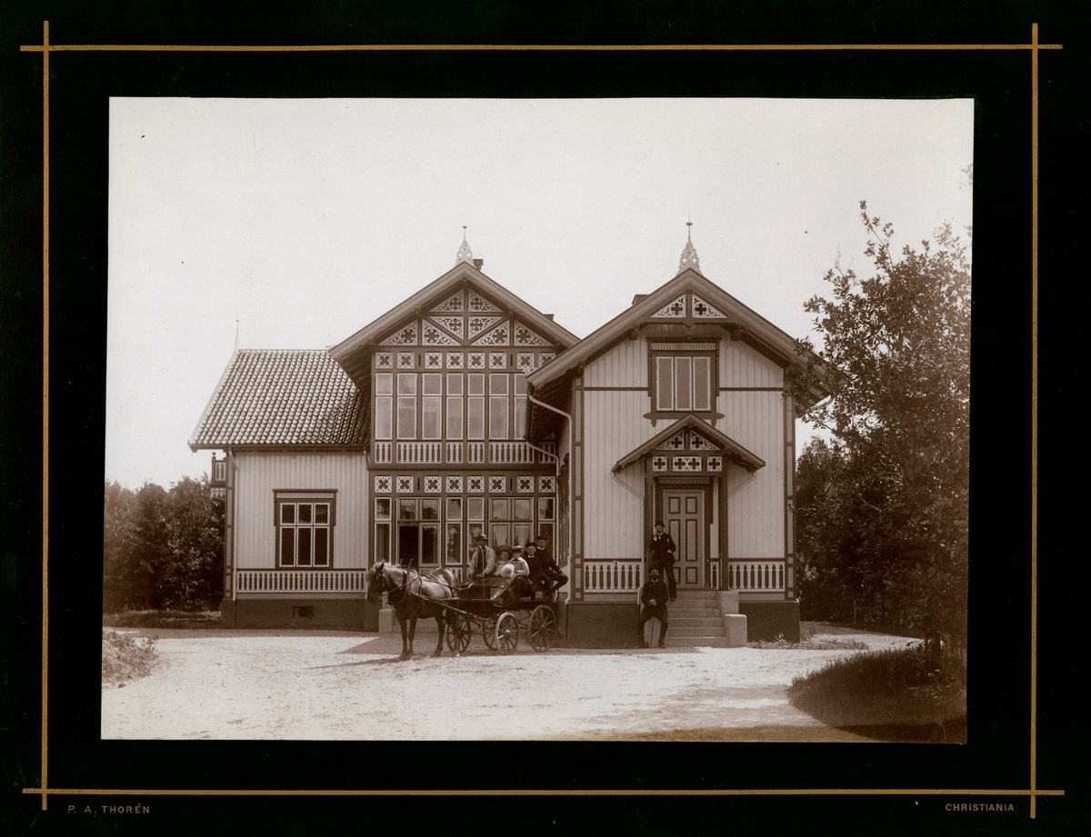 Fagerheim, Hisøy, Arendal. Stor sveitservilla tilh. familien Herlofson. Inngangspartiet med persongruppe på trapp og i hestekjøretøy.
Fra serie (NF.04551-001 til -021) fra billedmappen "Strømsbo", gård på Strømsbu i Arendal tilh. familien Herlofson. Bildene er fra ulike eiendommer og steder i Arendal tilknyttet familien, fotografert av P.A. Thorèn, Chra.