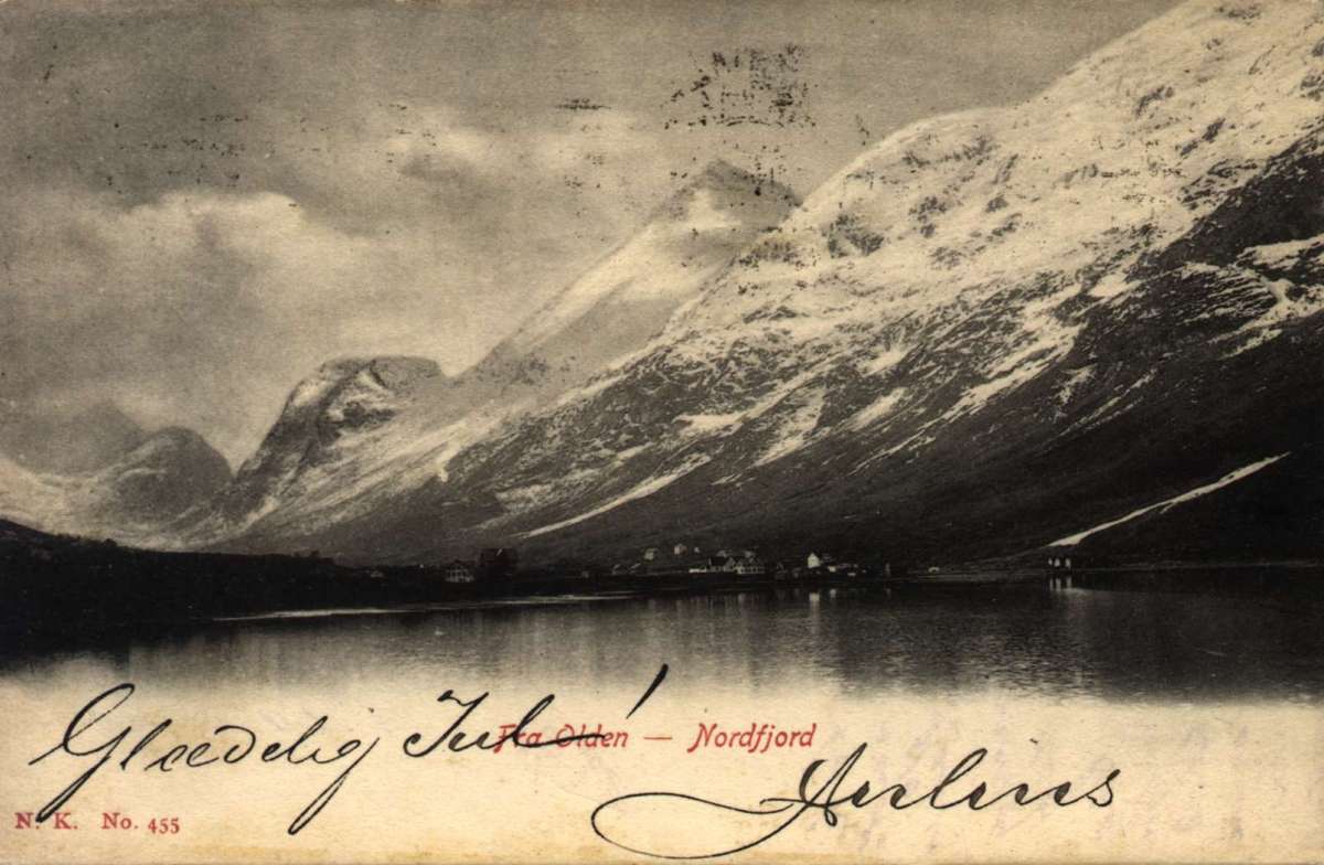 Postkort. Julehilsen. Fotografisk motiv. Svart/hvitt. Motiv fra Olden, Nordfjord. Landskap. Fjell med snø på toppene. Fjord. Bebyggelse. Stemplet 23.12.1906.