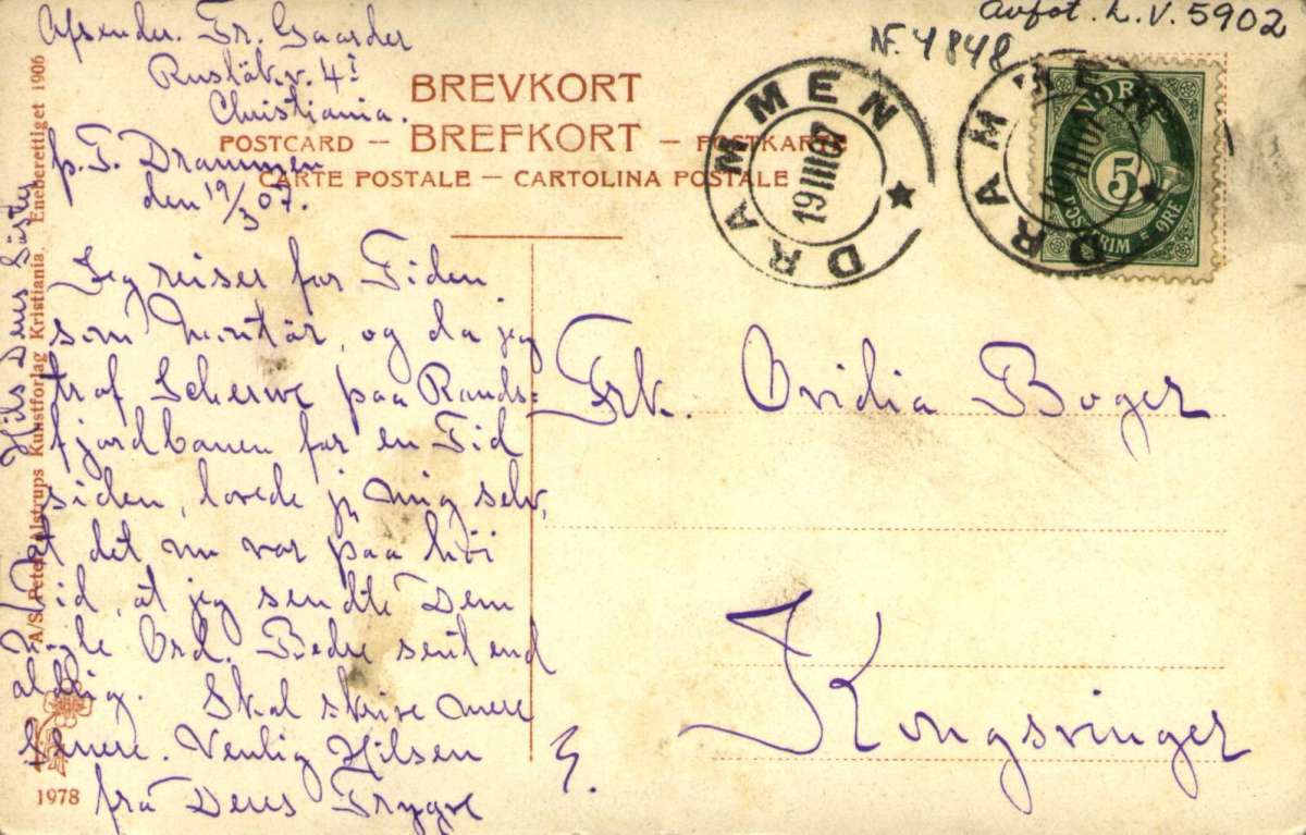 Postkort. Kirke ligger på den andre siden av broen. Mange mennesker rundt i byen. Stemplet 19.03.1907."Drammen. Fra Broen og Strømsø."