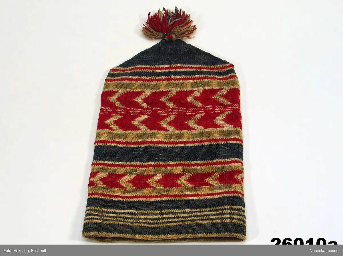 2 st röda toppluvor, A-B.
A.
B.Röd toppluva, maskinstickad i slätstickning av ullgarn, filtad, 2 stycken med nästan osynliga sidsömmar, hoptagningar i toppen. Liten röd ullgarnstofs högst upp. Nederkanten uppvikt 2 varv.

Berit Eldvik okt 2005