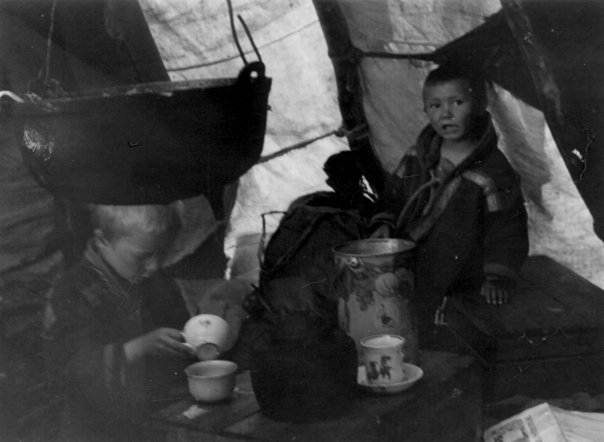 Interiør med Josef Henrik og Mikkel Perssen Buljo ved fokostbordet. Riverbukta 1952.