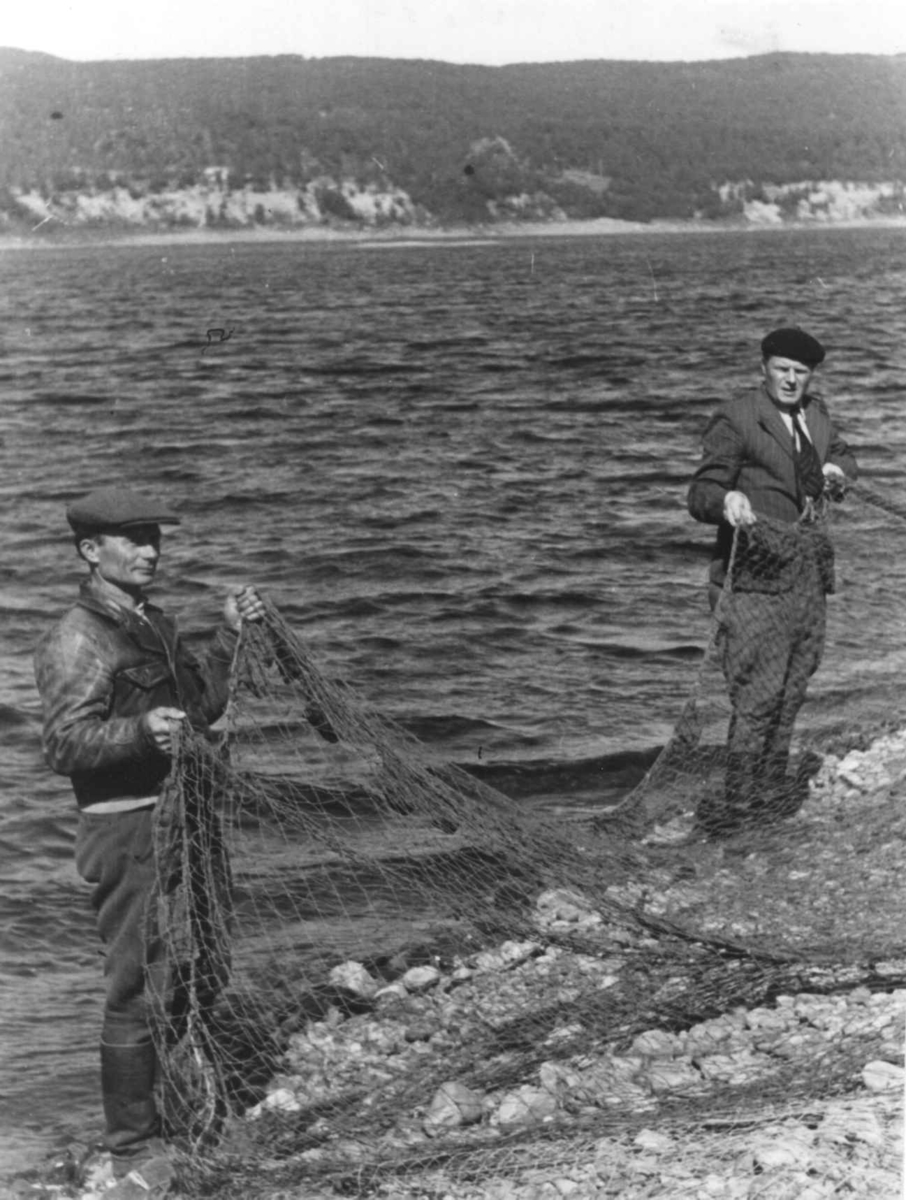 Vilkuna og Pekka Suomenrinne med en laksnot mellom seg  på stranden. Gakkur-gargo 1948.