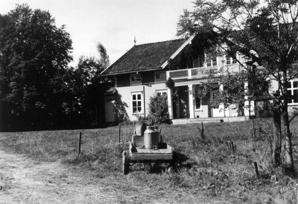 Sundby, Vestby, Akershus. Hovedhuset mot tunet med veranda. Hest og kjerre med melkespann fremst i bildet. Storgårdsundersøkelser ved dr. Eivind S. Engelstad 1953.
