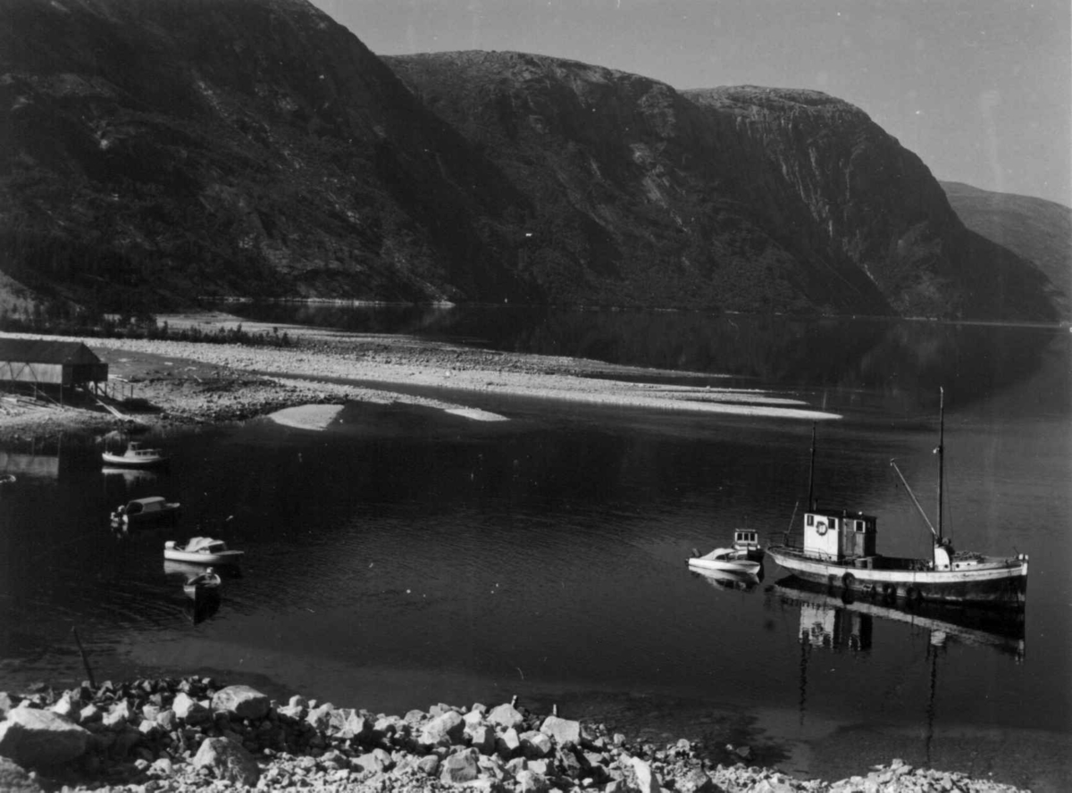 Oversiktsbilde over Hellemobotn, med båter, 1964. Mareno Mikkelsen fra Vuodnabáhta / Hellemobotn født 1947 forteller at sjarken oppe til venstre tilhørte Kaia og Theodor Andersen, en racer tilhørte Inga og Augun Karlsen og helt til høyre MK Harda.