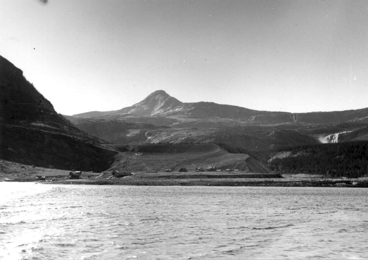 Oversiktsbilde over Hevsten-varre og Hellemobotn, 1964. Fjellet midt på bildet heter Tjuolak. Fossen helt til høyre heter Suovastiddje. Sagbruket tilhørte Anders Mikkelsen.