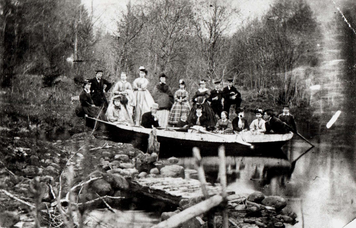 Gruppe, utflukt i robåt på gården Moen, Kviteseid, eid av propietær og landhandler Christian Munthe (1818-92), som også har tatt bildet ca.1860.