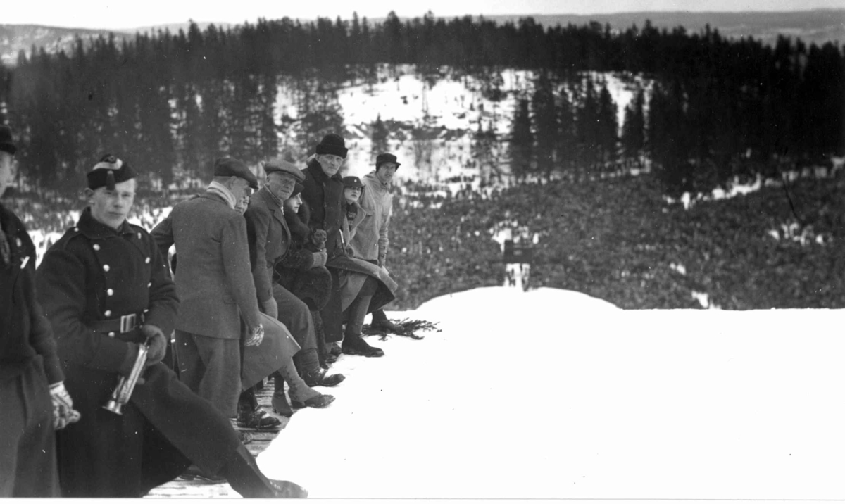 Ski. Hopprenn. Holmenkollen, Oslo 1934. Oversiktsbilde fra hoppet med unnarennet, publikumstribunen og Gratishaugen. Tilskuere på toppen av unnarennet.