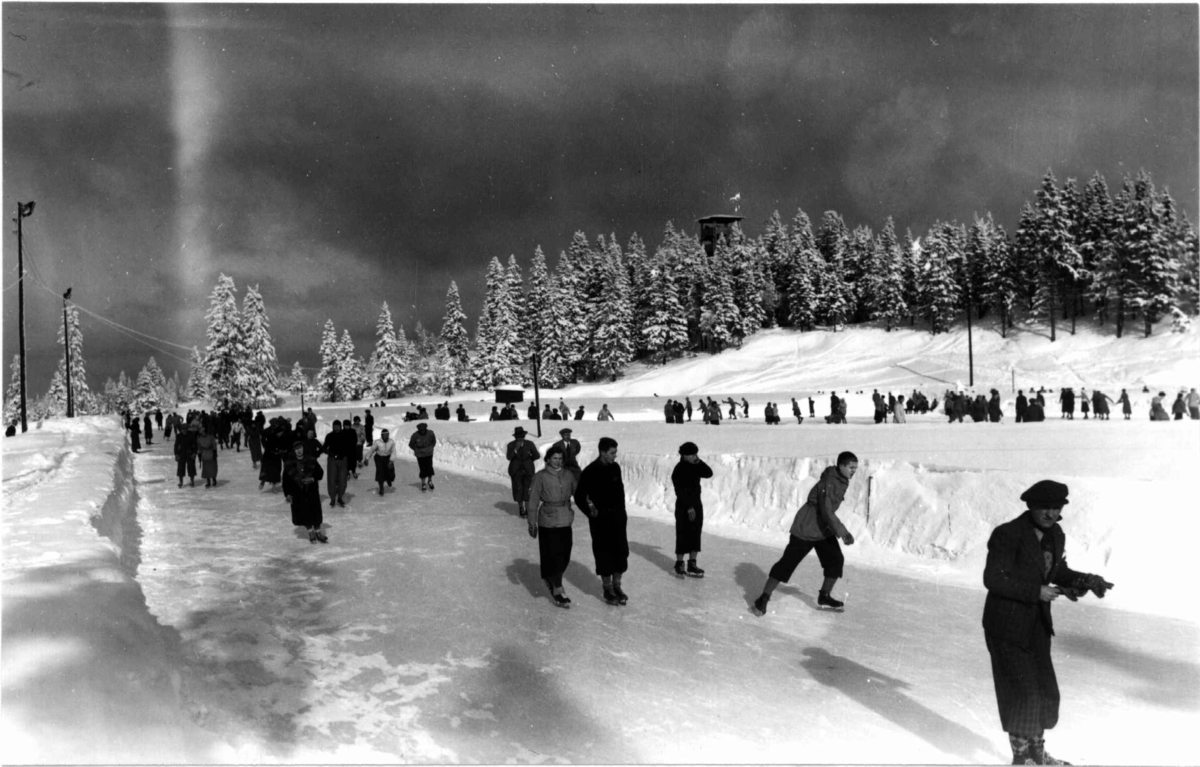 Tryvann skøytebane, Oslo. 1936. Skøyteløpere i sving på isen.