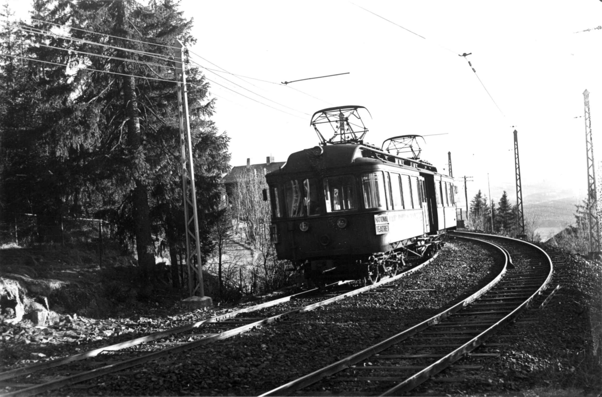 Holmenkollbanen, Nordmarka, Oslo. 1934. Skog med trikk og bane.