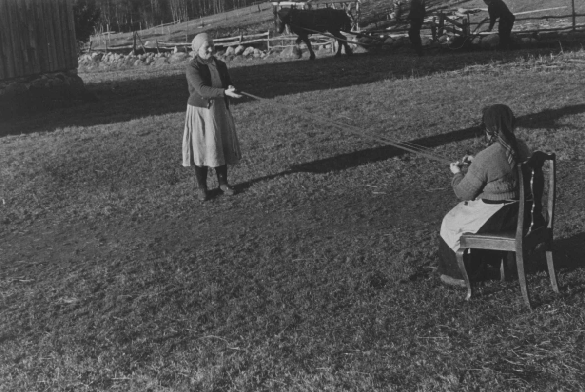 Bondekone Kristi Espeli og datteren lager snor til å ha nederst på stakk og kjoler. Åseral, Vest-Agder 1943.