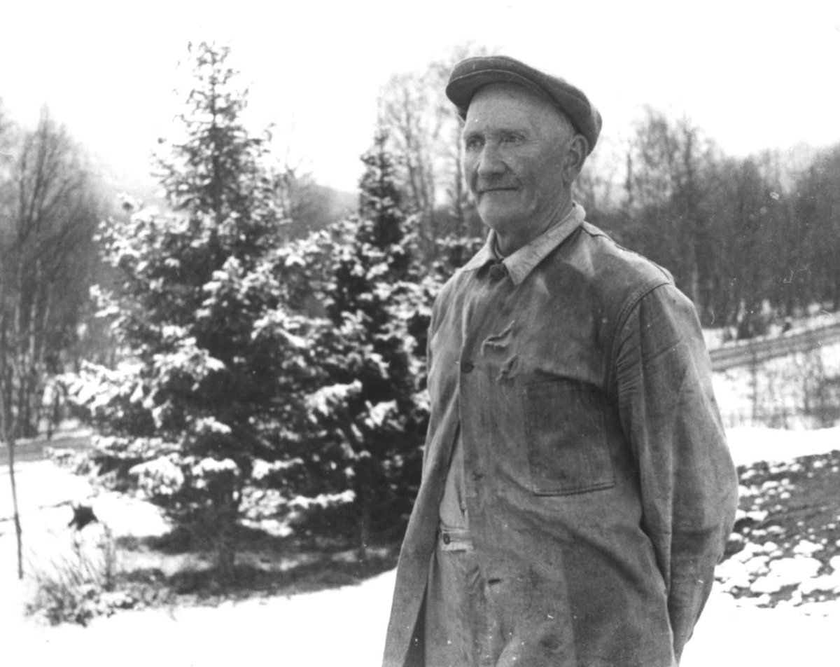 Portrett av ukjent mann med skyggelue. Skog i bakgrunnen. Rostadal, Målselv 1940-årene.