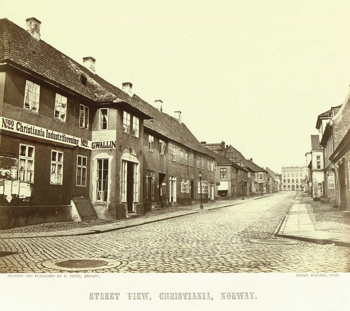 Gateparti, Kvadraturen, Oslo. Krysset Kongens gate/Tollbugata med Tollbugata 22, 24 og 26 til venstre. I enden av gata Øvre Vollgate 15. 
Fra serie norske landskapsfotografier tatt av den engelske fotografen Henry Rosling (1828-1911).