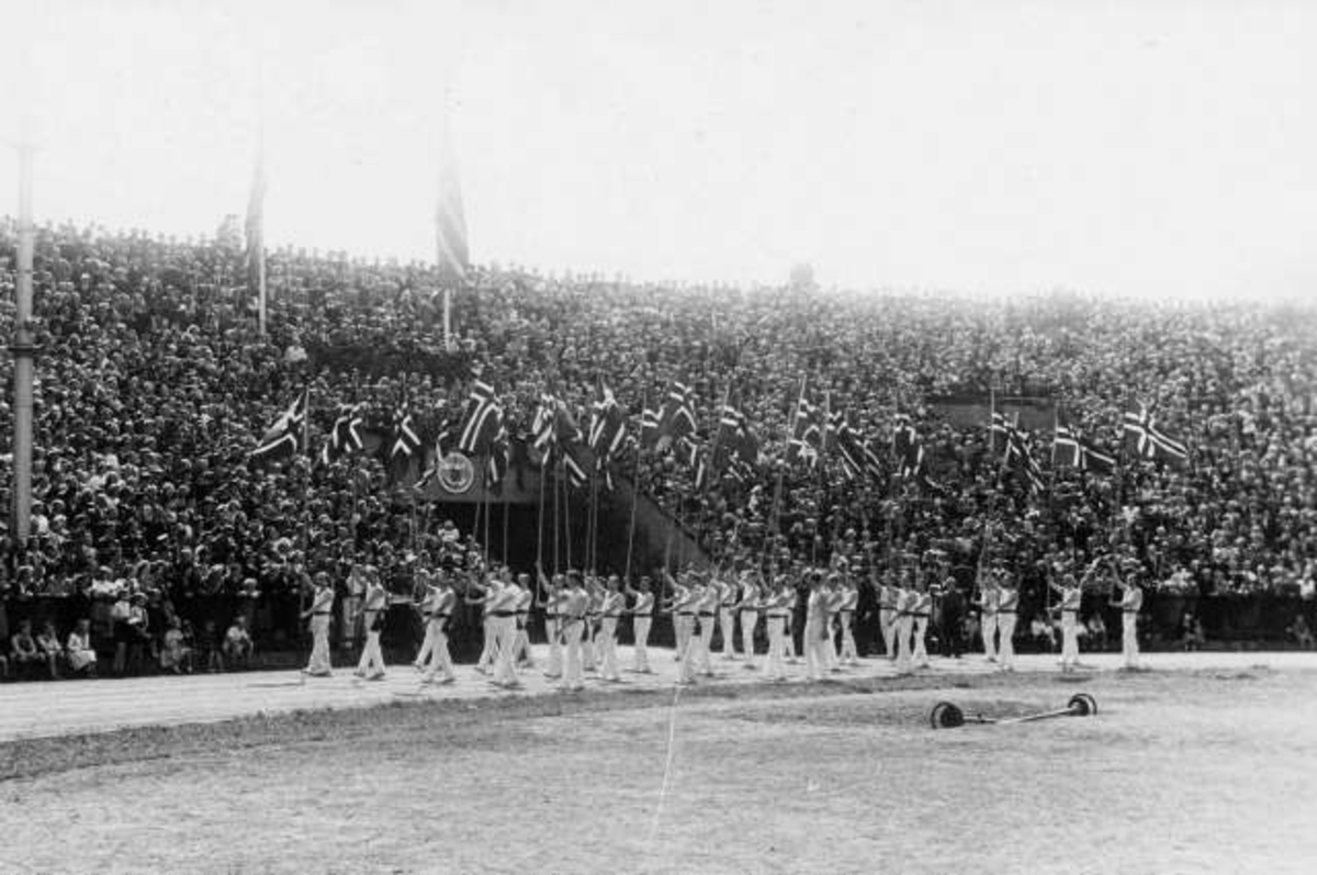 Fra Oslo under fredsdagene i 1945. Idrettens Dag på Bislett Stadion 3.jun.Idrettsmenn med flaggborg på den oppmerkede banen.