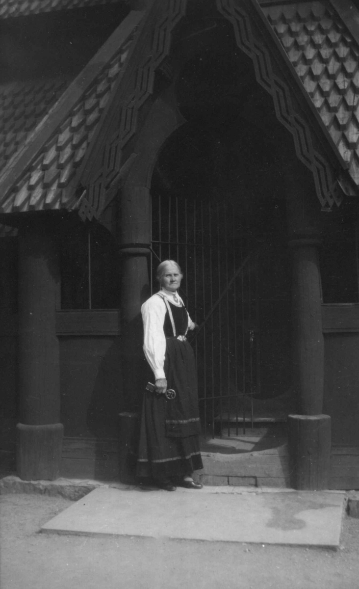 Ansatte, forøvrig museets eldste person i 1929, Asgjerd Haugen utenfor Stavkirken, bygning nr.181 på Norsk Folkemuseum.