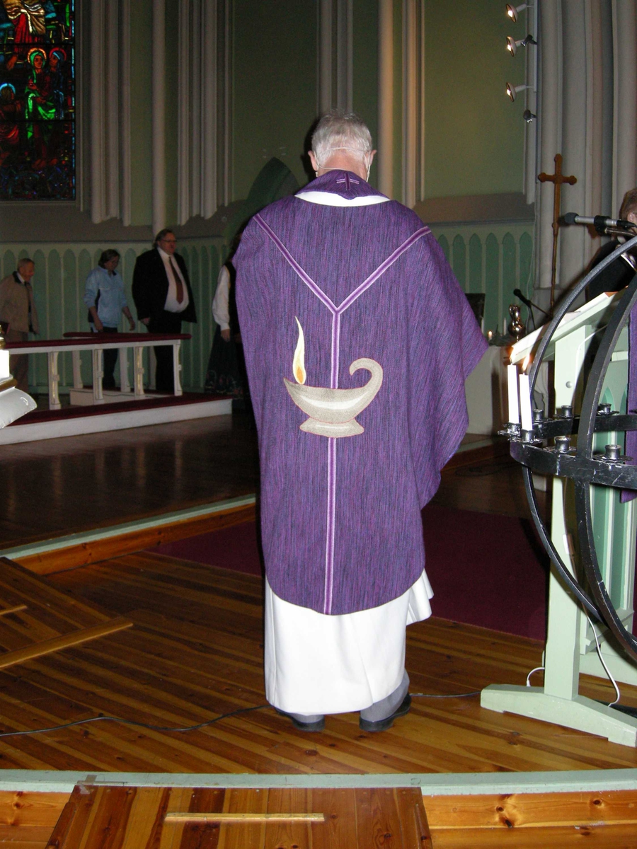 Første søndag i advent, åpning av kirkeåret. Sarpsborg kirke, Østfold, 02.12.2007. Prest kledd i lilla messehagel med gaffelkors og lampe som symbol på ryggstykket.