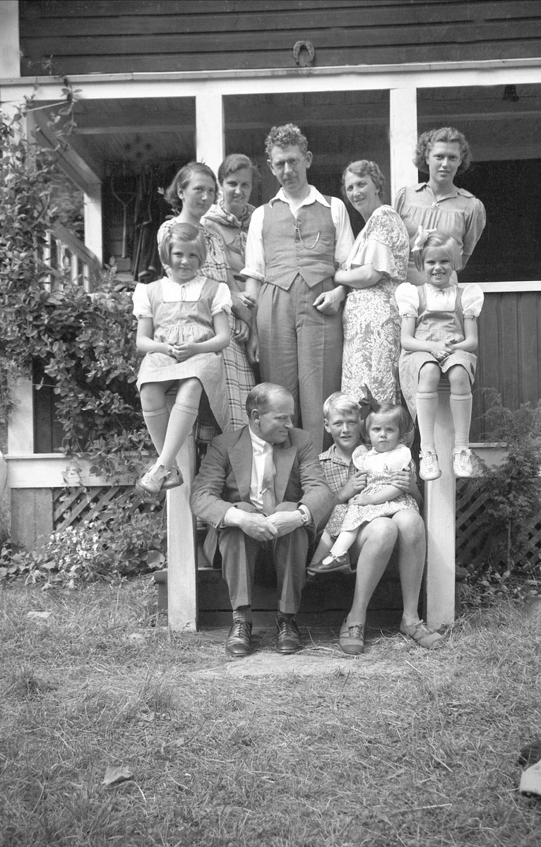 Johannes og Jofrid Smith med barna, Dordi og Fritjof Arentz 
med barna Kari, Siri og Guri stående samlet på en trapp på hytta til Smith på Storøya, Sandefjord, Vestfold. Fotografert 1937.