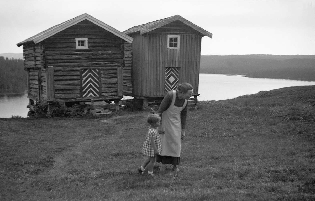 Gården Lauvnes, Sigdal 1938.  Kari Arentz sammen med kona på gården står foran stabburene