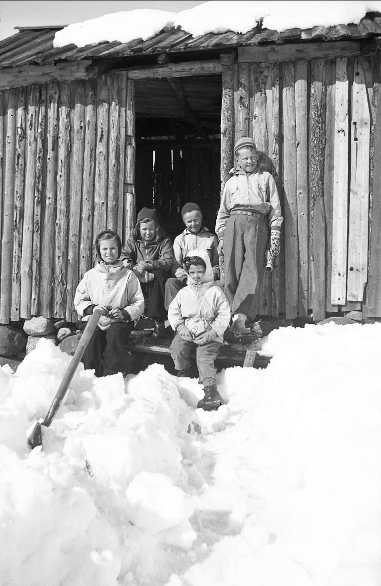 Vintermotiv fra Ligardshaug 1942. Søstrene Arentz og brødrene Jebsen på vedskjultrappa. Fra venstre Siri og Guri Arentz, Bernt og Jørgen Jebsen. Foran sitter Kari Arentz.