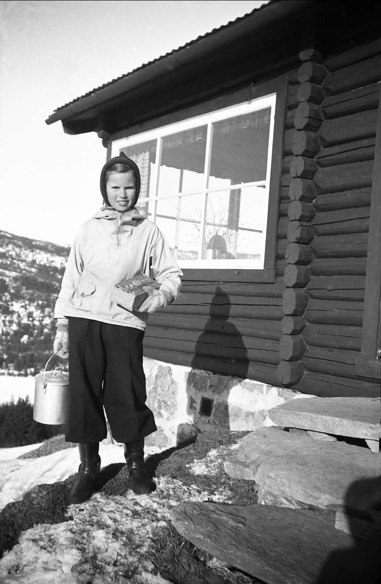 Guri står på trappa på Ligardshaug 1942. Hun  bærer på et melkespann.