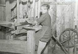 Husflid. Kvinne vever gardiner.