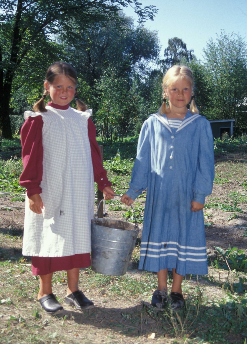 Barn i drakter med bøtte
i friluftsmuseet i 2002.